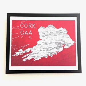 Framed map of Cork GAA on a red background with white lettering and detailed location names, conveying a sense of regional pride and history.