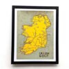 Framed map highlighting Irish golf courses. Ireland is depicted in yellow with black markings, set against a muted green background. Text reads "Irish Golf."