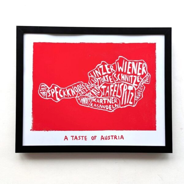 Framed art print of Austria's map with terms like "Wiener," "Schnitzel," and "Speckknödel" on a red background. Text below reads "A Taste of Austria."