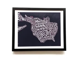 Framed artwork of Howth peninsula map. Names of locations and features form the shape, in white text on a black background. Modern and artistic.