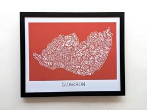 Framed map artwork of Luberon on a red background. Place names form the shape of the region in white text. Elegant and modern design.