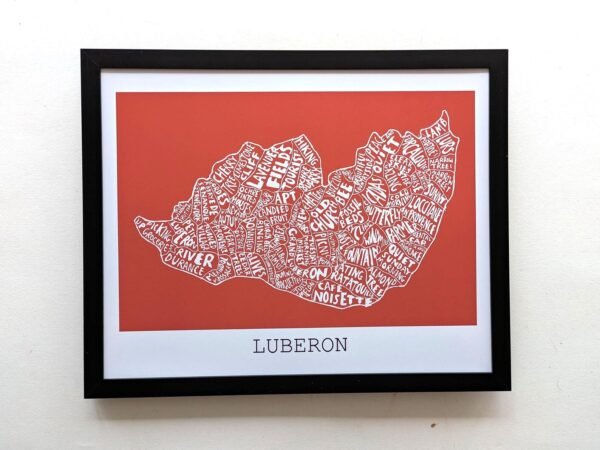 Framed map artwork of Luberon on a red background. Place names form the shape of the region in white text. Elegant and modern design.