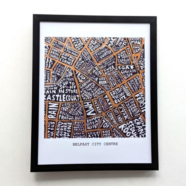 Framed artwork depicting a map of Belfast City Centre. Streets are creatively labelled with white text on an orange background, forming a complex pattern.
