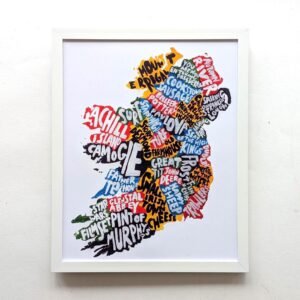 Framed artwork of Ireland's outline with colorful words like "Achill," "Murphy's," and "Abbey." The vibrant design highlights cultural elements.