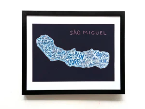 Framed artwork of São Miguel island on a dark background. Island shape is filled with blue words like "forest" and "Azores," conveying adventure.
