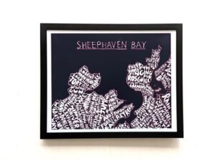 Framed artwork titled "Sheephaven Bay" features a map with place names creatively forming the landmasses. Black background with white text.