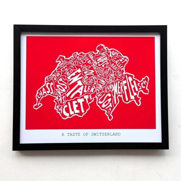 Framed artwork of Switzerland's map with food names in stylized white text on red. Caption reads "A Taste of Switzerland." Bold, cultural theme.