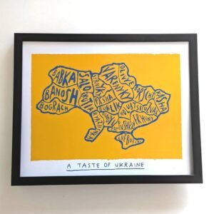 Framed artwork depicting Ukraine's map made of food names in blue on a yellow background. Below, text reads "A Taste of Ukraine" in bold.