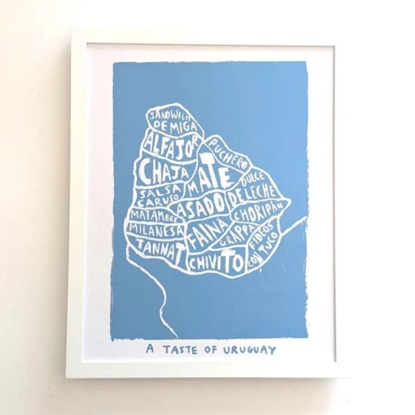 Framed artwork on a white wall depicts Uruguay's map with names of local foods like alfajor and chivito in artistic font. Text below reads "A Taste of Uruguay."