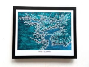 Framed Cork Harbour map illustration showing intricate handwriting on a textured teal background. The artistic map highlights details and locations.