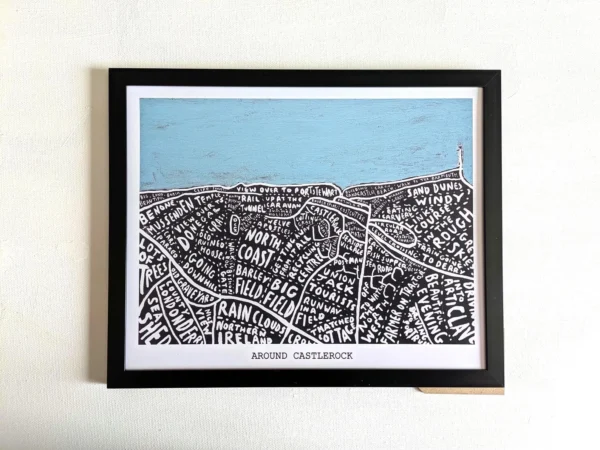 Framed illustration titled "Around Castlerock" with stylized black and white map details of places, topped by a painted light blue sky.
