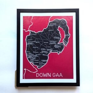 Framed artwork of Down GAA clubs map, black silhouette on dark red background, white lettering naming various clubs. Bold text at bottom reads "DOWN GAA."
