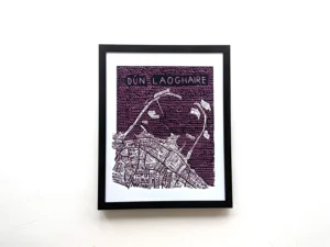 Framed artwork of Dún Laoghaire features a detailed street map with names in white on a dark purple background, conveying a modern, artistic vibe.