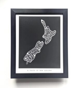Framed black-and-white map of New Zealand made with food names like "pavlova" and "hokey pokey." Text below reads "A Taste of New Zealand." Minimalist design.